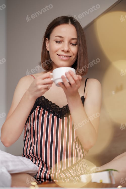 Preview: Woman Enjoying Morning Tea in Cozy Bed