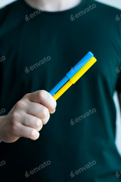 Preview: Support for Ukraine in the war with Russia. A man holds yellow and blue felt-tip pens
