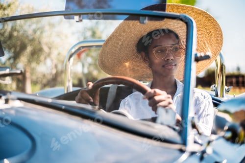 Preview: Black woman driving a vintage convertible car
