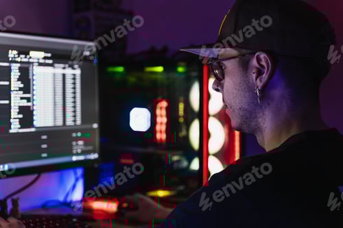 Preview: Professional editor working with his computer full of LED lights in his work office
