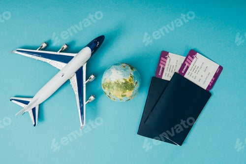 Preview: top view of globe and plane models, passports with tickets on blue background