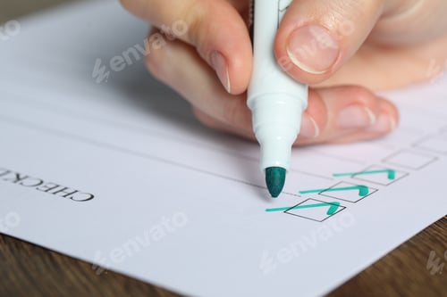 Preview: Woman checking box of paper form at wooden table, closeup