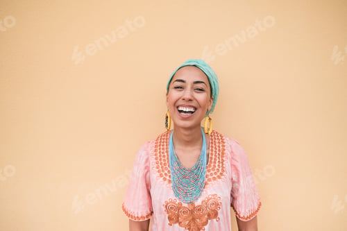 Preview: Young mixed race woman smiling on camera while wearing traditional dress