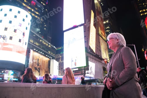 Preview: Happy mature woman with white hair having fun on vacation in Times Square