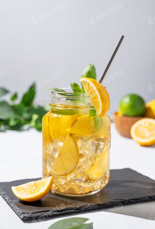Preview: Lemonade drink or cold tea with fresh lemon, mint in a jar. Refreshing citrus mojito cocktail