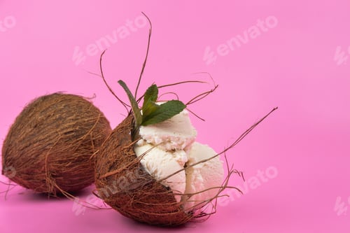 Preview: Vanilla ice cream balls in an empty coconut decorated with mint leaves on a pink background