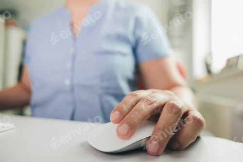 Preview: Left-handed woman's hands working with computer mouse