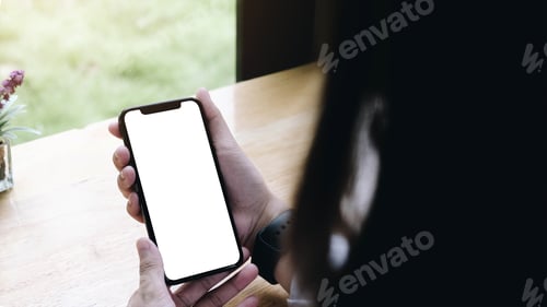 Preview: Mockup image of woman's hands holding white mobile phone with blank screen.