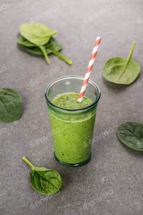 Preview: Spinach leaves and green organic smoothie in glass with straw