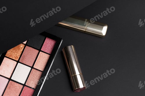 Preview: various makeup products on black texture background.