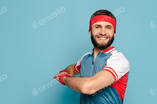 Preview: happy stylish sportsman exercising on blue background