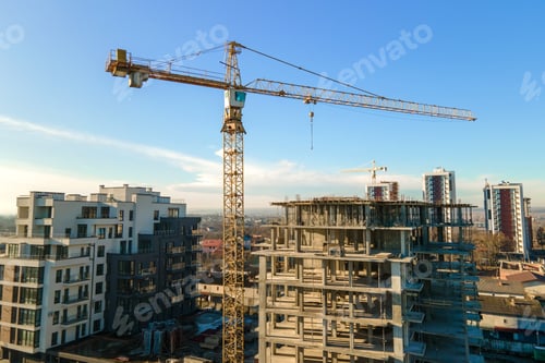 Preview: Aerial view of high tower crane and residential apartment buildings under construction. Real estate