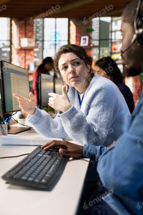 Preview: Call center manager supervising man logging customer interactions in CSM system