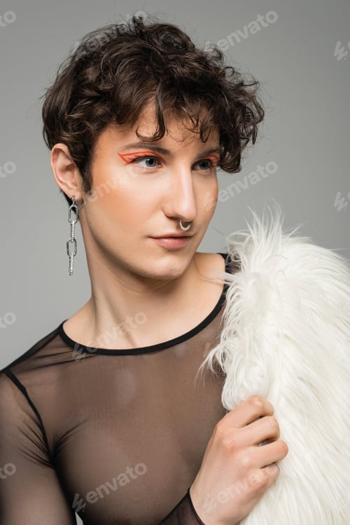 Preview: portrait of young pansexual person with makeup holding white faux fur jacket and looking away