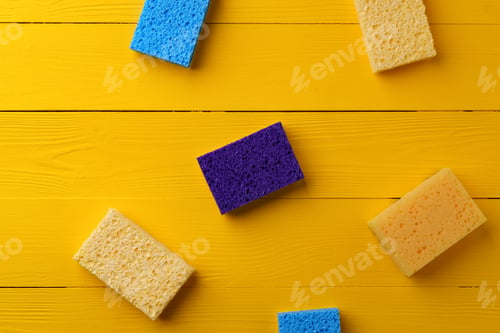 Preview: Cleaning sponges on yellow wooden background flat lay