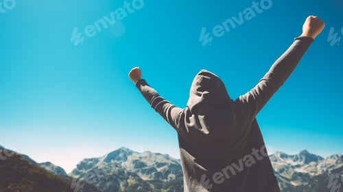 Preview: Winning and success. Victorious female person on mountain top.