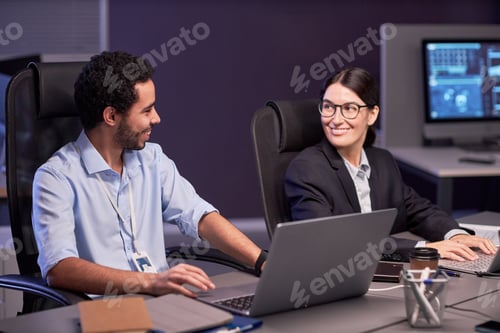 Preview: Two smiling business people discussing project in meeting