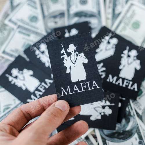 Preview: KYIV, UKRAINE - NOVEMBER 22, 2019: cropped view of man holding playing card with mafia letters near