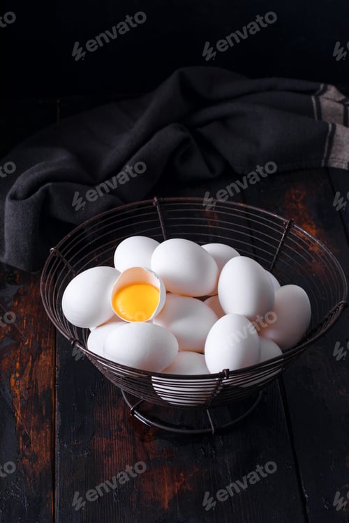 Preview: Basket of colorful fresh eggs on wooden table rustic background.