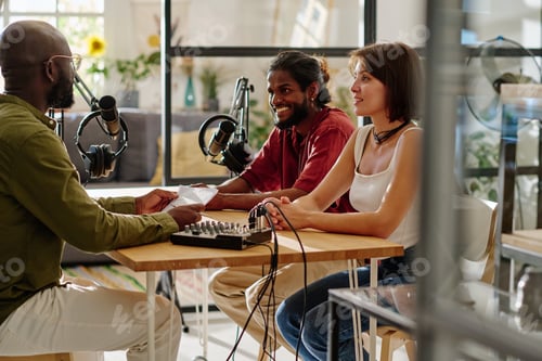 Preview: Group of young multicultural people sitting by desk in front of each other