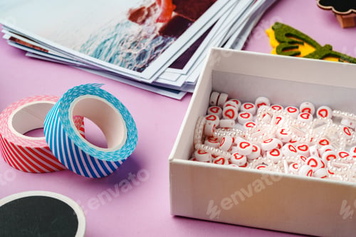 Preview: Crafting supplies for scrapbooking arranged on a purple surface