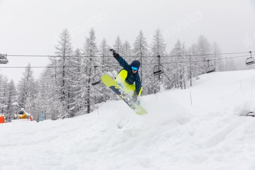 Preview: Snowboarder jumping on snowy mountain slope
