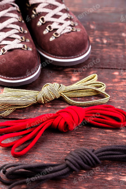 Preview: Brown man suede boots and shoelaces on wooden background. Autumn or winter shoes.