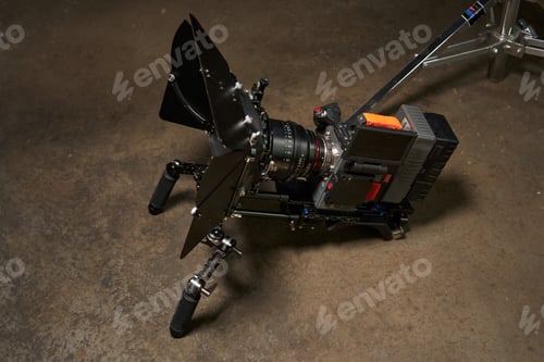 Preview: a professional movie camera stands on a concrete floor in an assembled state.