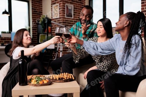 Preview: Joyful group of multiethnic people toasting at wine party while celebrating friendship event