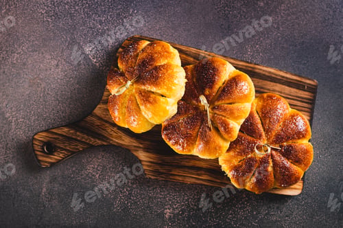 Preview: Close up of sweet pumpkin buns on a board on the table top view