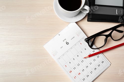 Preview: Busy day ahead with organized calendar, coffee, and reading glasses on wooden table