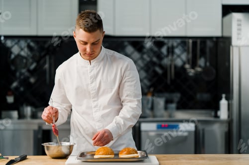 Preview: Professional kitchen chef prepares burgers greases buns