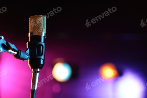 Preview: Microphone on stand against color background with blurred lights, space for text. Bokeh effect