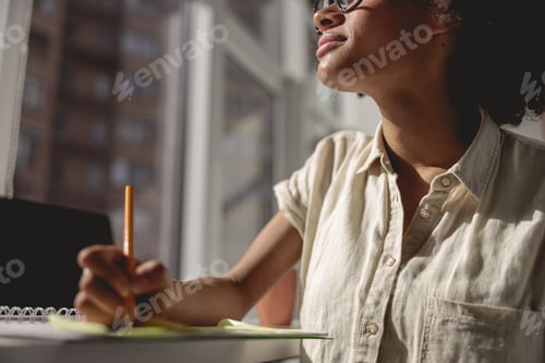 Preview: Pretty Afro American woman looking out the window