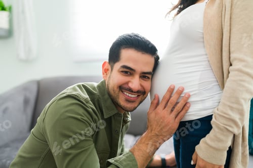 Preview: Latin man hearing his baby moving in the belly of his wife