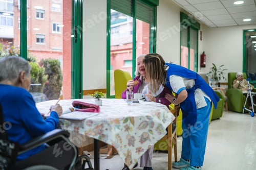 Preview: Nurse showing affection to senior woman in nursing home