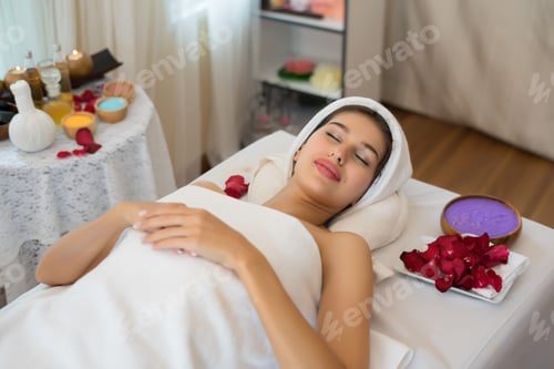 Preview: Beautiful smiling woman with flowers resting in the spa before massage.