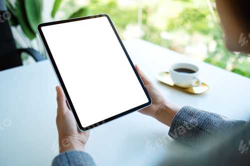 Preview: Mockup image of a woman holding digital tablet with blank white desktop screen in the office
