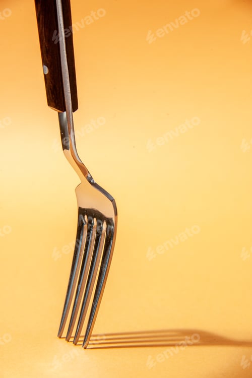 Preview: Top view of kitchen cutlery set putting upside down on golden background with free space