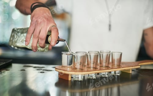 Preview: Cropped shot of an unidentifiable bartender pouring shots behind the bar