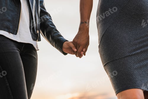 Preview: Close-up of lesbian couple holding hands outdoors