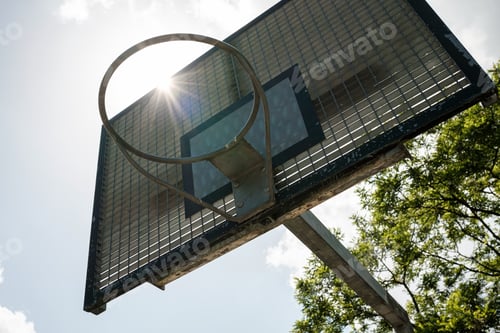 Preview: Basketball basket on sun, sky and tree background. Outdoor sports ground.