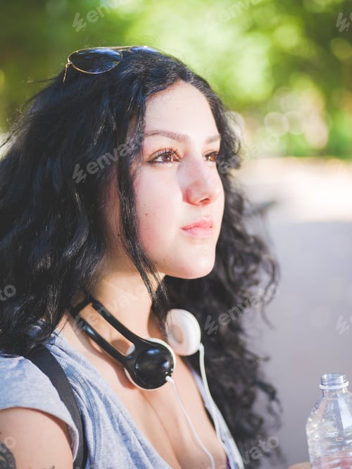 Preview: Portrait of a young mixed race curly black hair woman with headphones