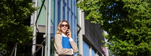 Preview: Working lady in sunglasses, saleswoman talking on mobile phone in front of office building