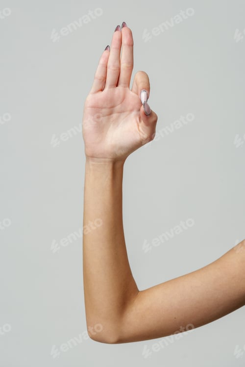 Preview: Woman's Hand Showing Three Fingers Against a Light Grey Background
