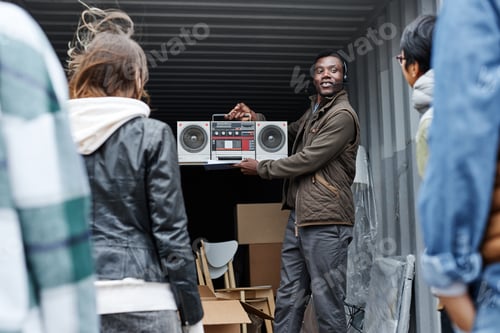 Preview: Smiling black auctioneer holding vintage boombox