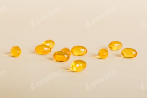 Preview: Heap of yellov pills on colored background. Tablets scattered on a table. Pile of red soft