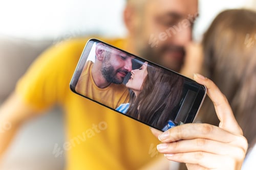 Preview: Close Up Of Beautiful Young Couple Is Taking Photo For Their Love Story While Using Smartphone