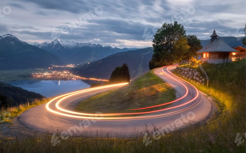 Preview: Light trails of cars on a road to the water and illuminated building in Zell am See, Austria