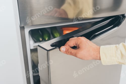 Preview: cropped view of man open fridge door